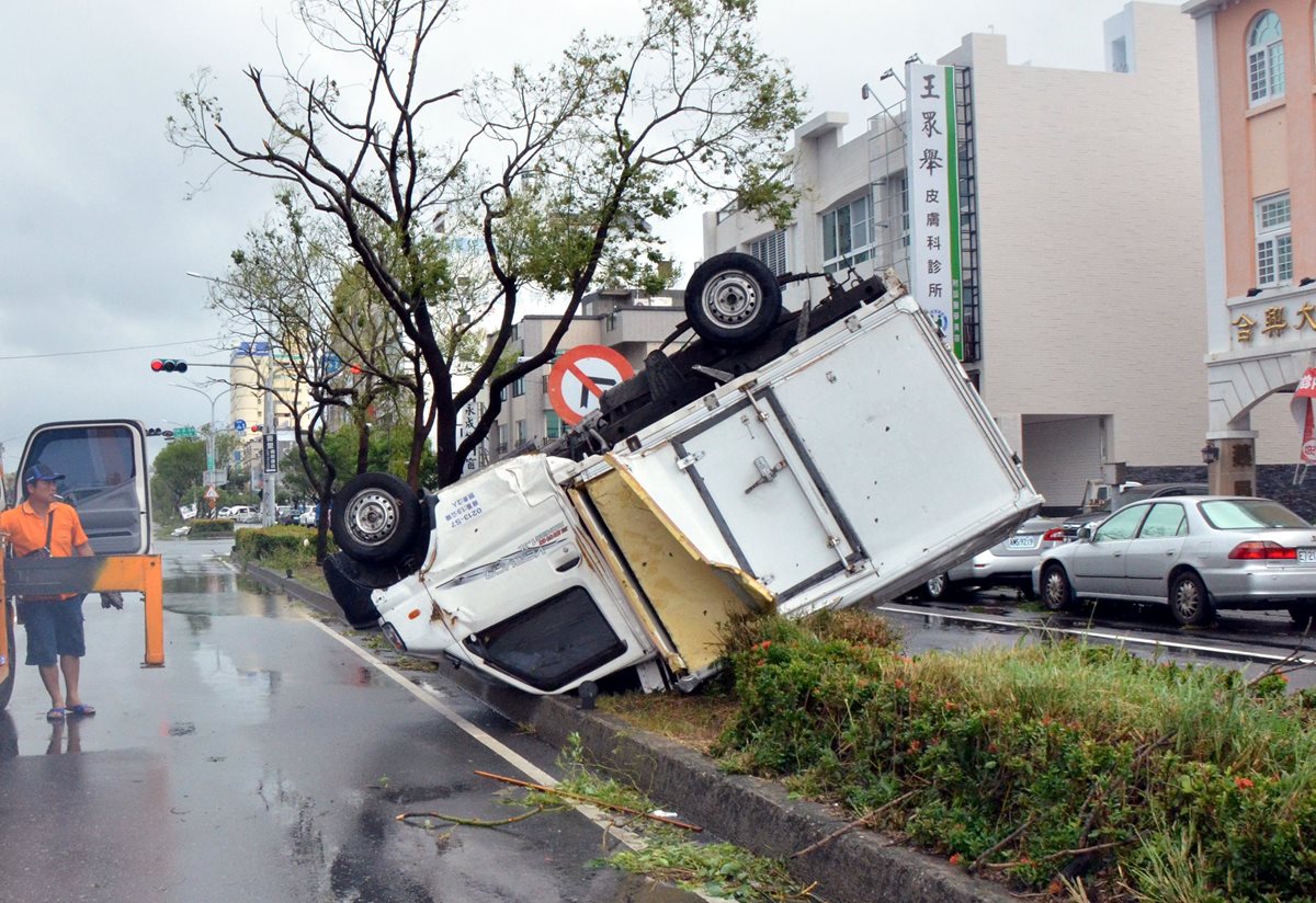 Un camión volcado se ve en una calle de Taitung tras el paso del supertifón. (Foto Prensa Libre: AFP).