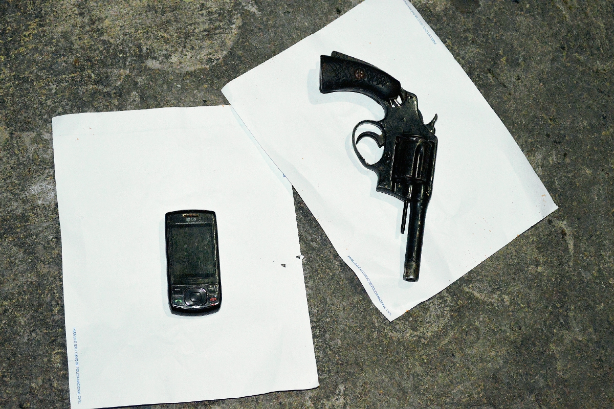 Teléfono celular y arma que le fueron decomisados a Carlos de León, en Chiantla, Huehuetenango. (Foto Prensa Libre: Mike Castillo)