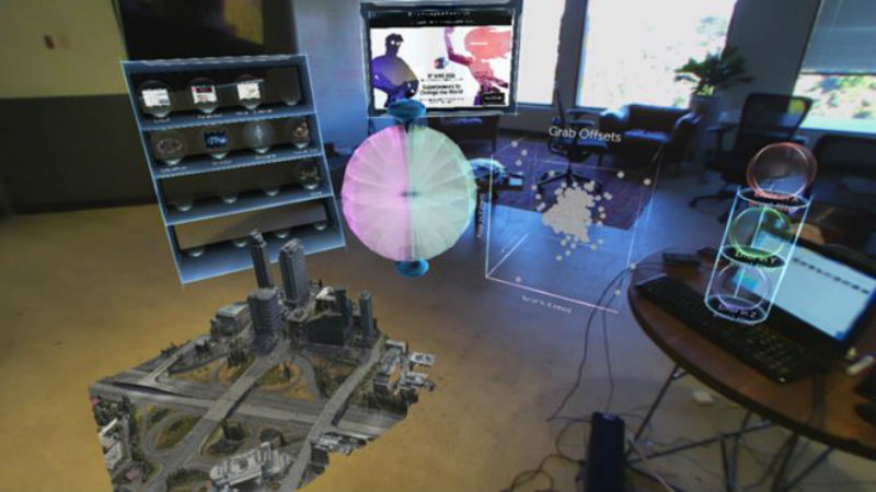 El sistema superpone hologramas en una oficina real, permitiendo manipular elementos con las manos. (METAVISION.COM)
