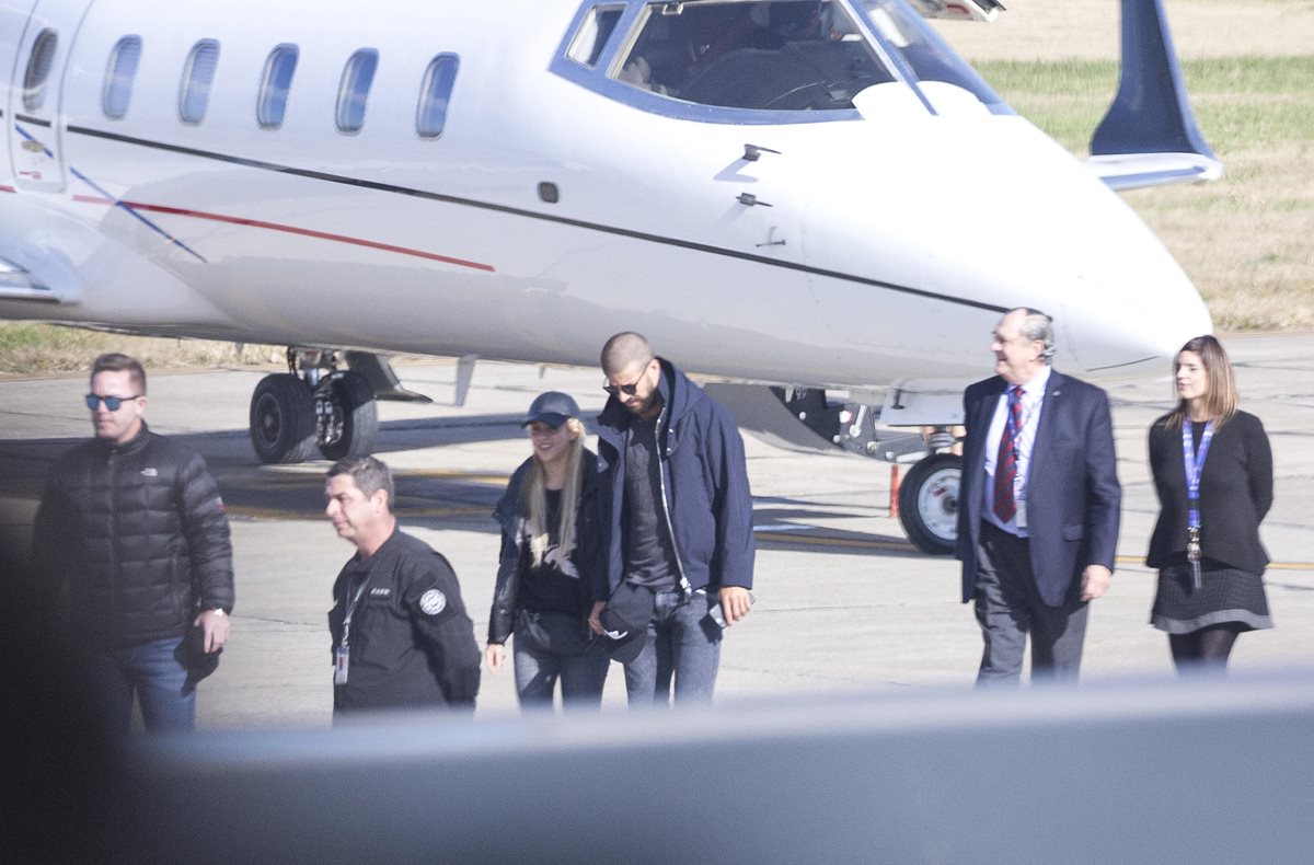 El jugador, del FC Barcelona, Gerard Piqué (c-d) y su pareja, la cantante colombiana Shakira (c-i), llegan al aeropuerto de Rosario para asistir al matrimonio del futbolista argentino, y también jugador del Barcelona, Lionel Messi. (Foto Prensa Libre: EFE)