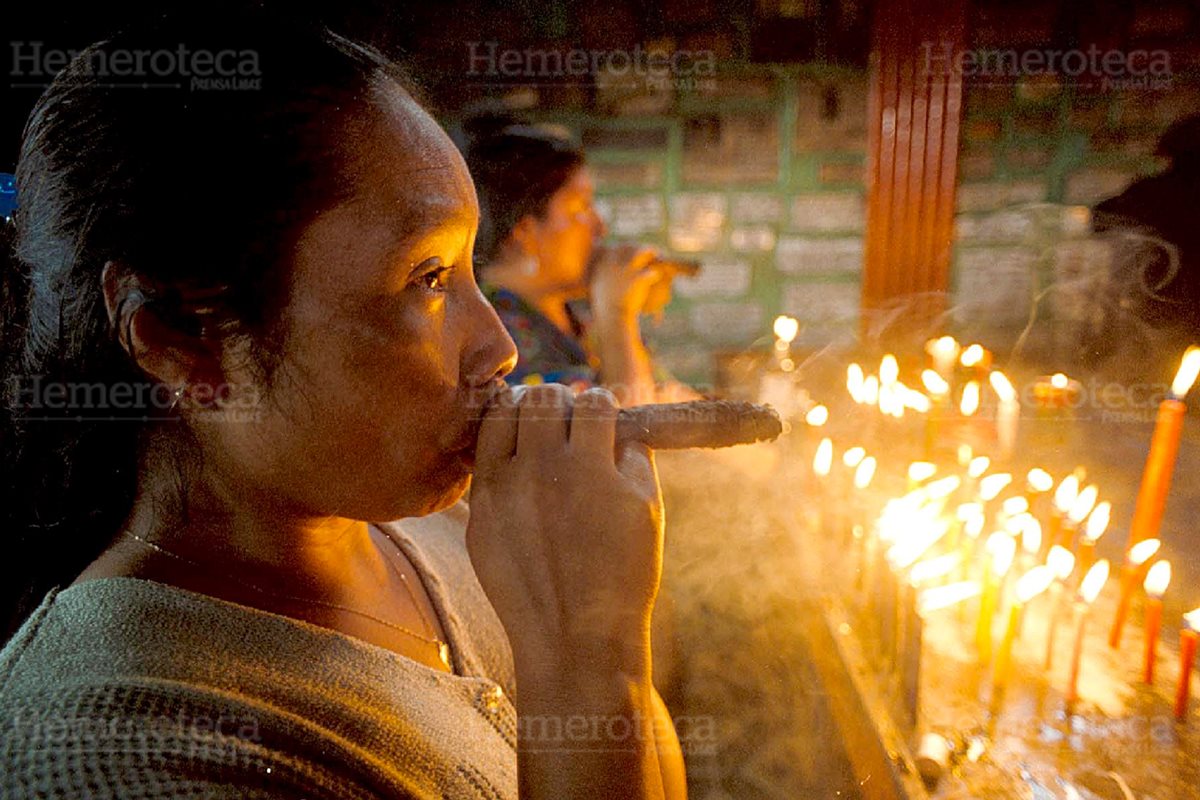Una mujer fuma un puro en el rito conocido como “la limpia”. (Foto: Carlos Sebastián)