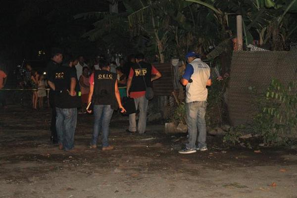 Agentes del MP buscan evidencias en la escena donde fue asesinado el cobrador de préstamos. (Foto: Prensa Libre)
