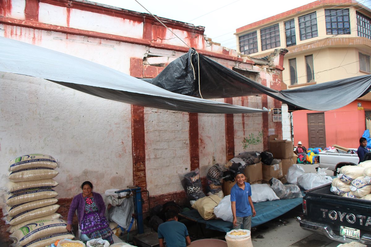 Comerciantes de la zona 4 de la cabecera de Totonicapán ubican sus ventas a costado del edificio dañado. (Foto Prensa Libre: Édgar Domínguez)