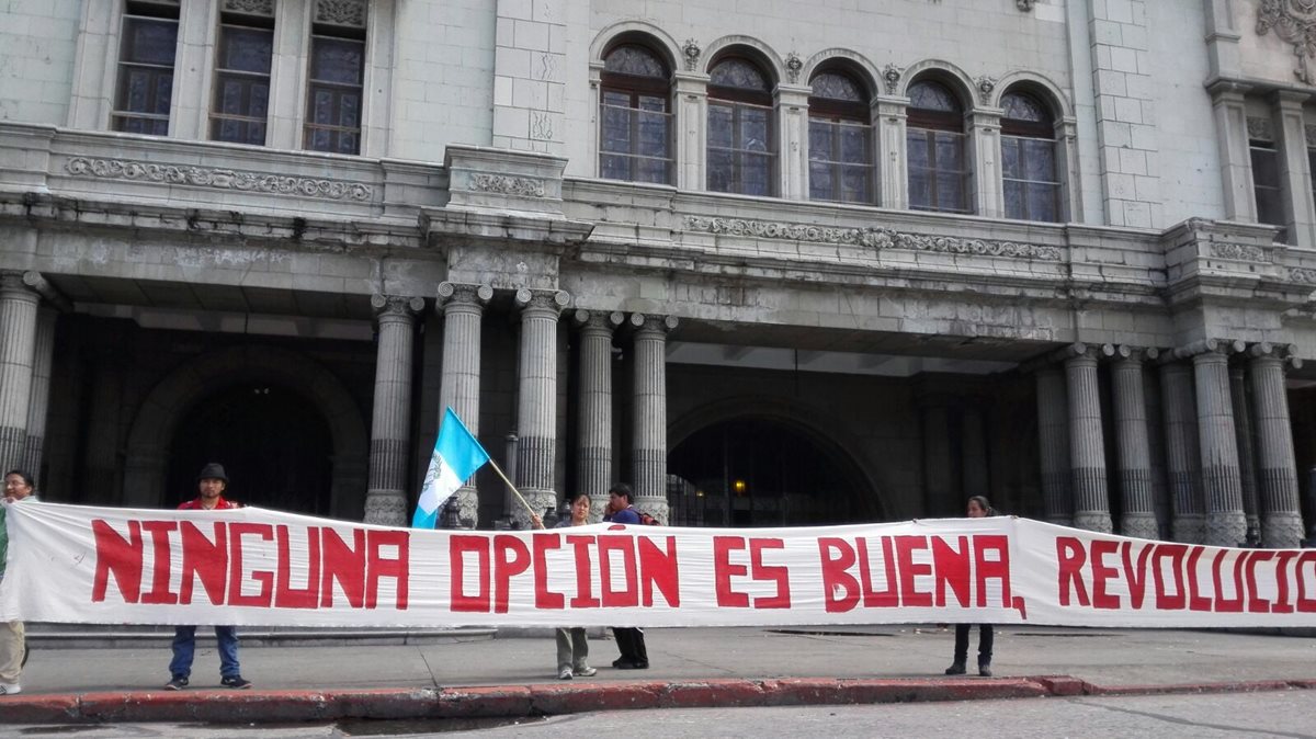 Un grupo de jóvenes colocó mantas frente al Palacio Nacional de la Cultura en rechazo a las elecciones. (Foto Prensa Libre: E. Castro)