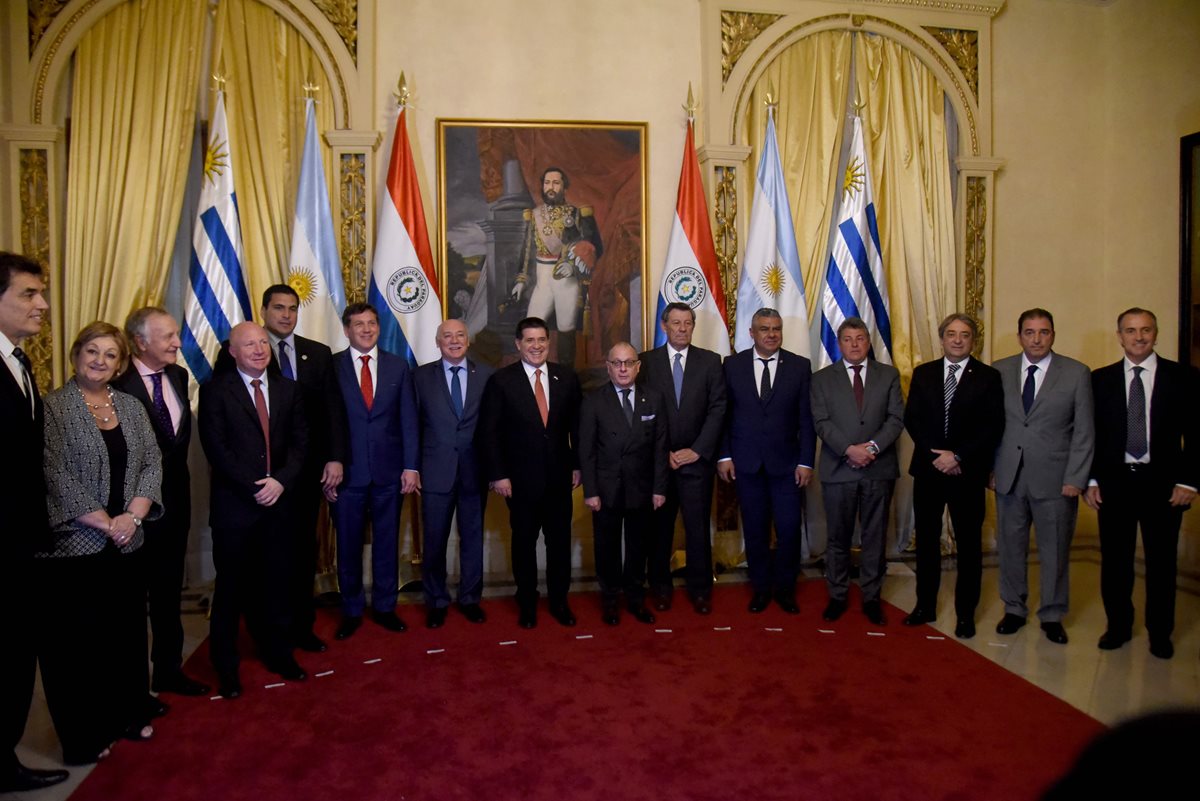 Autoridades de Argentina, Paraguay y Uruguay posan con el presidente paraguayo, Horacio Cartes (C) luego de la firma del acuerdo de cooperación para la candidatura del Mundial de 2030. (Foto Prensa Libre: AFP)