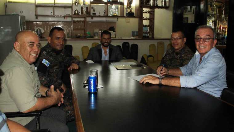 El presidente de Aurora, Carlos Castro junto a otros integrantes de la directiva militar, firman el contrato con el técnico Ariel Sena.