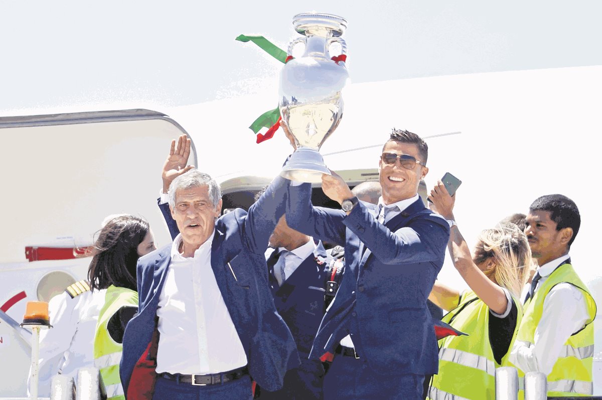 El técnico Fernando Santos junto a Cristiano Ronaldo cuando regresaron a Portugal, con el título de campeones de la Eurocopa. (Foto Prensa Libre: AFP)