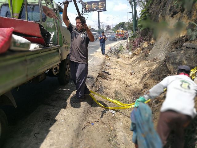 Trabajadores de la Municipalidad de Mixco recogen piezas del tráiler que se accidentó en el kilómetro 18.5 de la ruta Interamericana. (Foto Prensa Libre: Esbin García)