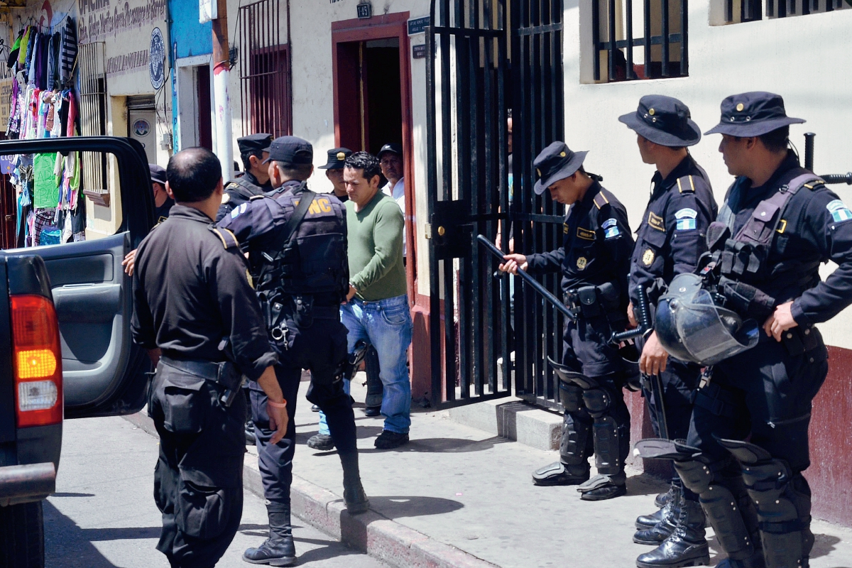 Agentes de la Policía Nacional Civil en el instante en que los dos presuntos extorsionadores salen de hospital para ser trasladados a la cárcel El Boquerón, Cuilapa, Santa Rosa. (Foto Prensa Libre: Oswaldo Cardona)