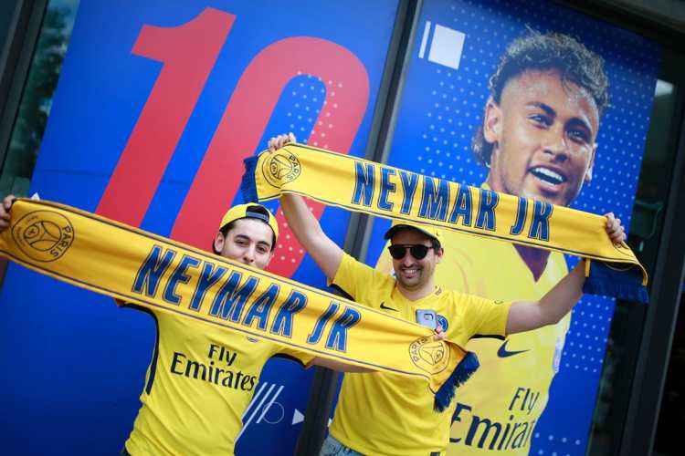 Aficionados del París Saint-Germain presumen sus camisolas y bufandas de Neymar. (Foto Prensa Libre: AFP)