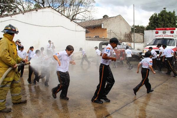 graduandos son bautizados con   agua lanzada desde una  unidad contra incendios.