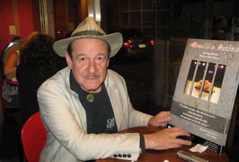 el realizador muestra un afiche de la producción audiovisual.