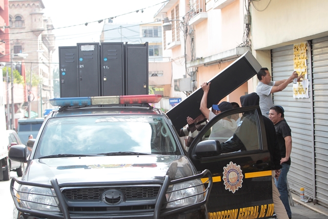 Agentes de la PNC cargan una autopatrulla con artículos que se encontraban dentro de la sede. (Foto Prensa Libre: Erick Ávila)