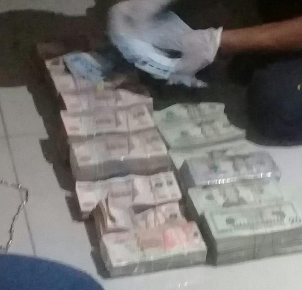 Investigador contabiliza parte del dinero decomisado en Tecún Umán. (Foto Prensa Libre:  PNC).
