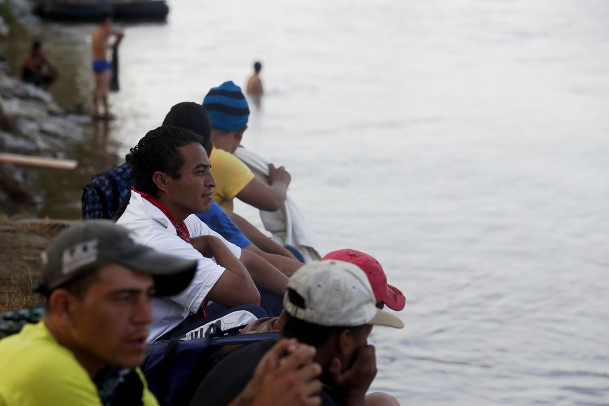 Migrantes hondureños observan desde orilla del río Suchiate a integrantes de Marina mexicana. (Foto Prensa Libre: EFE)