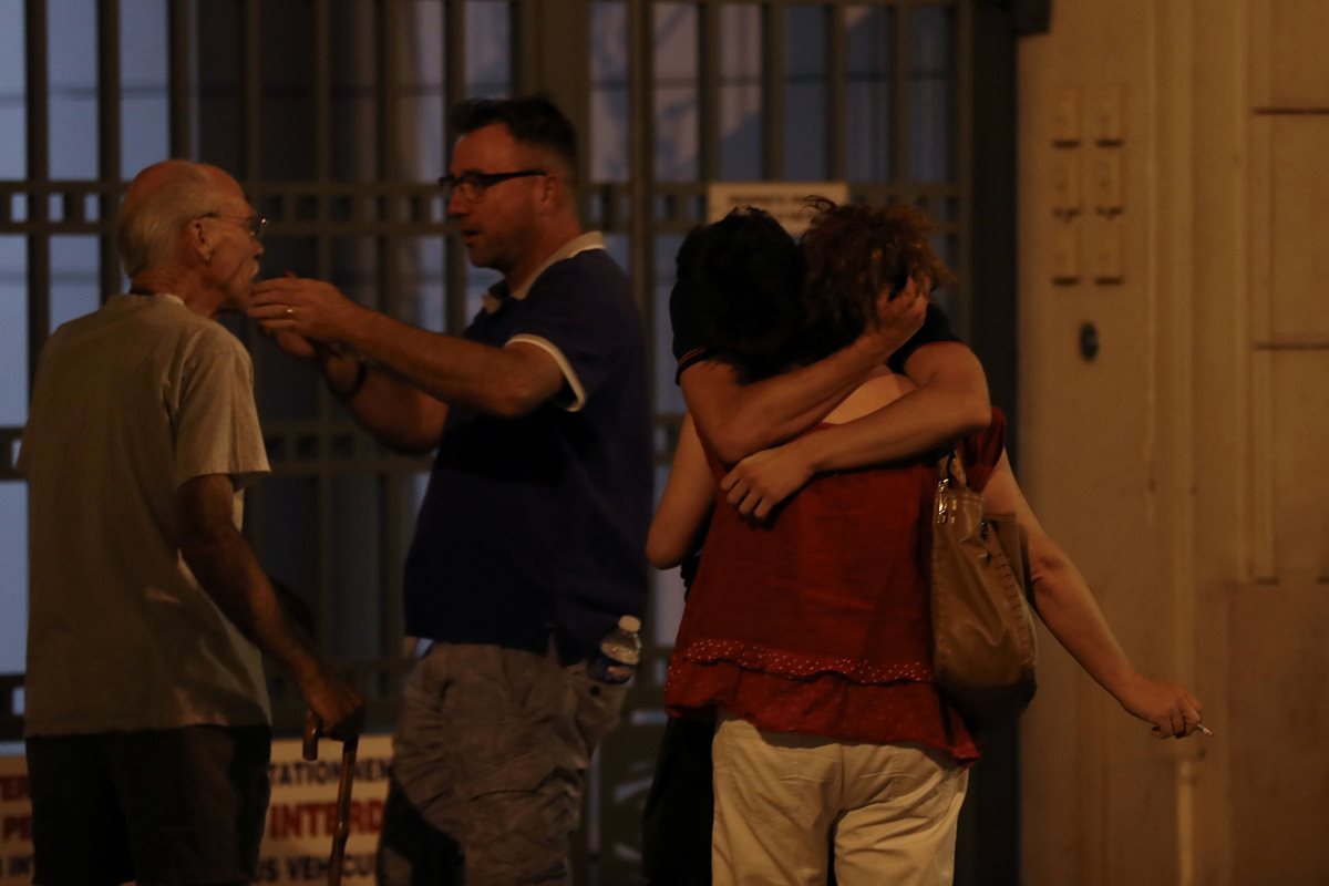 Familiares y amigos de las víctimas del ataque en Niza, Francia, se abrazan. (Foto Prensa Libre: AFP).