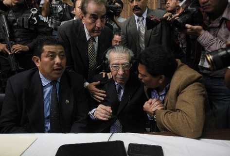 LOS Abogados Jaime Hernández —Izq.— y Francisco García —Der.— dan aliento al general Efraín Ríos Montt, luego de escuchar el fallo que lo condenó a 80 años de cárcel.