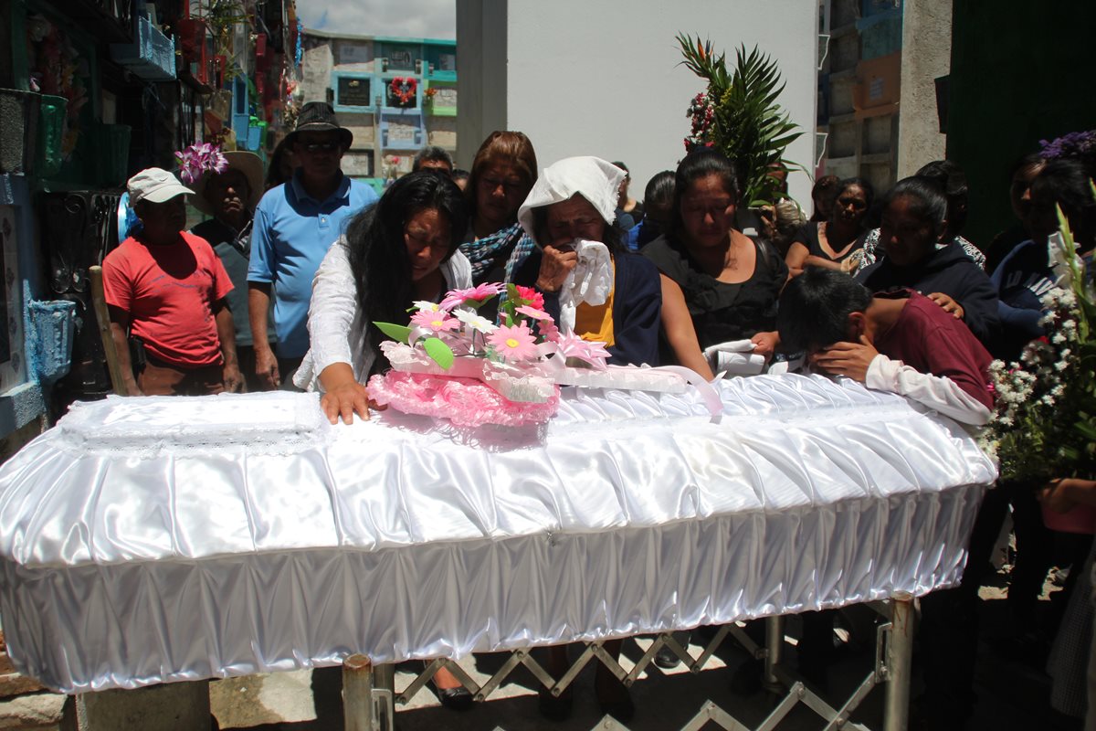 Familiares lloran frente al féretro de Daily Anali Domingo, quien fue sepultada este viernes en el Cementerio General de Huehuetenango. (Foto Prensa Libre: Mike Castillo)