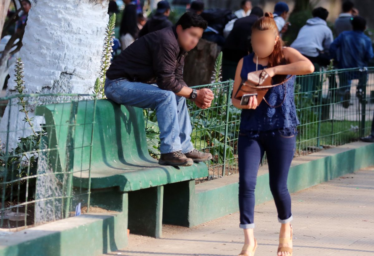 Una mujer camina en un parque de Xela, ante la mirada de un hombre. En esos sitios es donde las mujeres sufren mayor acoso. (Foto Prensa Libre)