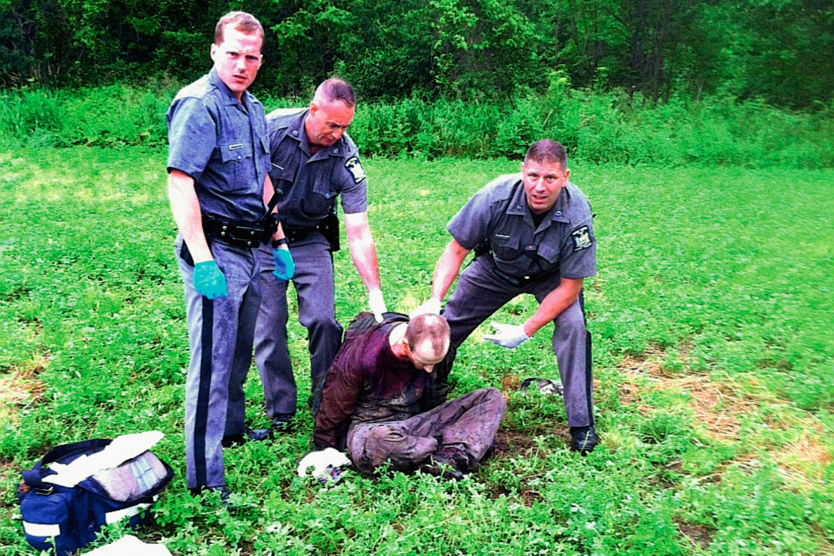 David Sweat es detenido por dos policías cerca de la frontera con Canadá. Foto Prensa LIbre:AP