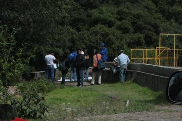 Autoridades inspeccionan el cadáver de una persona localizado en un río en Cantel, Quetzaltenango. (Foto Prensa Libre: Alejandra Martínez)