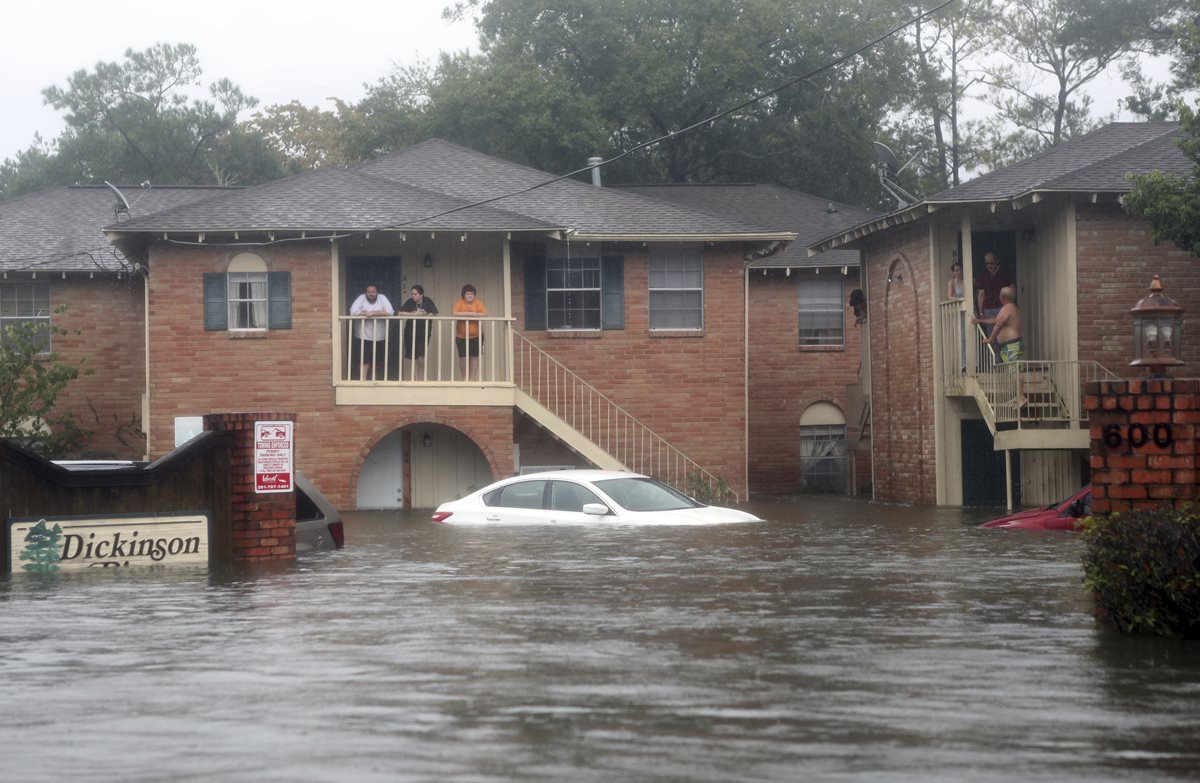 Una familia espera ayuda en el segundo piso de un complejo de apartamentos en Dickinson, Texas.(AP).