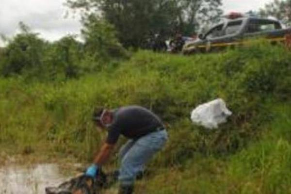 El cadáver de un hombre fue localizado en una cuneta en un sector de Poptún, en Petén. (Foto Prensa Libre: Rigoberto Escobar)