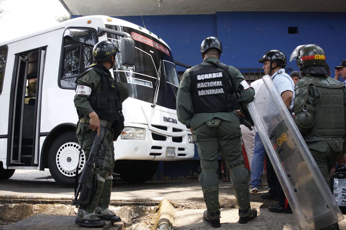 Oficiales venezolanos custodian el bus que atropelló a los policias. (Foto Prensa Libre: AFP).