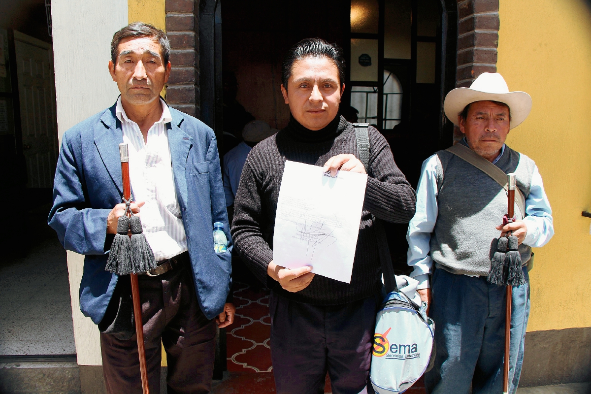 Líderes comunitarios  muestran el documento en el que se indica la razón del porque el alcalde de Momostenango los acusa de coacción. (Foto Prensa Libre: Édgar Domínguez)