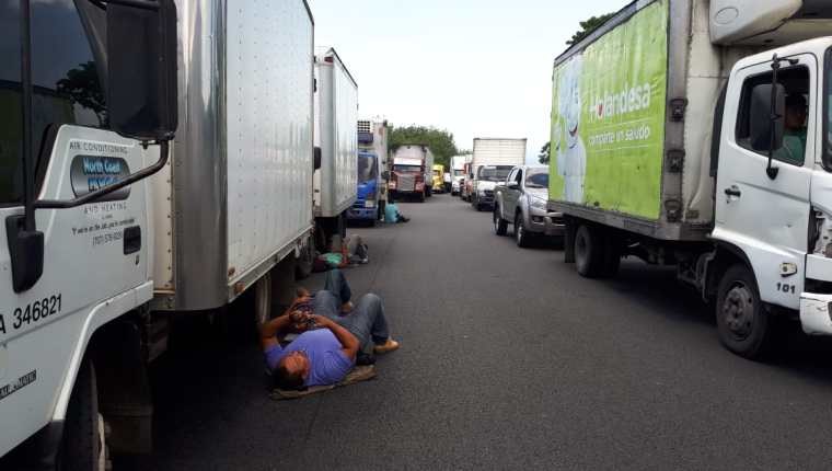 Pilotos de camiones descansan, debido a que por el bloqueo no pueden transitar. Muchos de los productos que transportan son perecederos. (Foto Prensa Libre: Rolando Miranda)