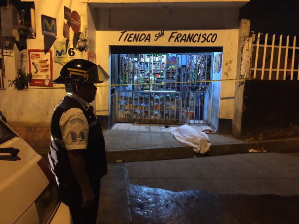 Un Bombero Voluntario observa el cadáver de la víctima, acuchillada frente a una tienda en la aldea Chichimecas, Villa Canales. (Foto Prensa Libre: Cortesía CVB)