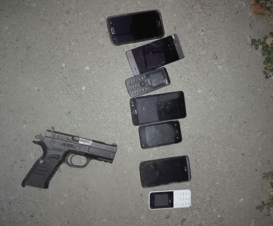 Arma de fuego y teléfonos móviles decomisados a cinco menores en la zona 6 de la capital, quienes eran buscados mediante la alerta Alba-Keneth. (Foto Prensa Libre: PNC)