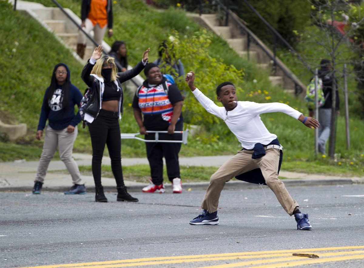 Jóvenes negros lanzan piedras a los agentes de la Policía en Baltimore. (Foto Prensa Libre: AP).