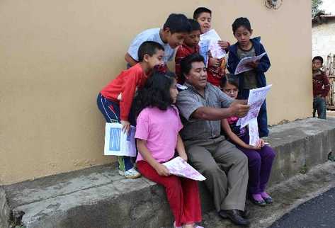 Un grupo de niños escuchan una de las historias que incluye la revista  Witzitzil,  editada por  Juan Yool.