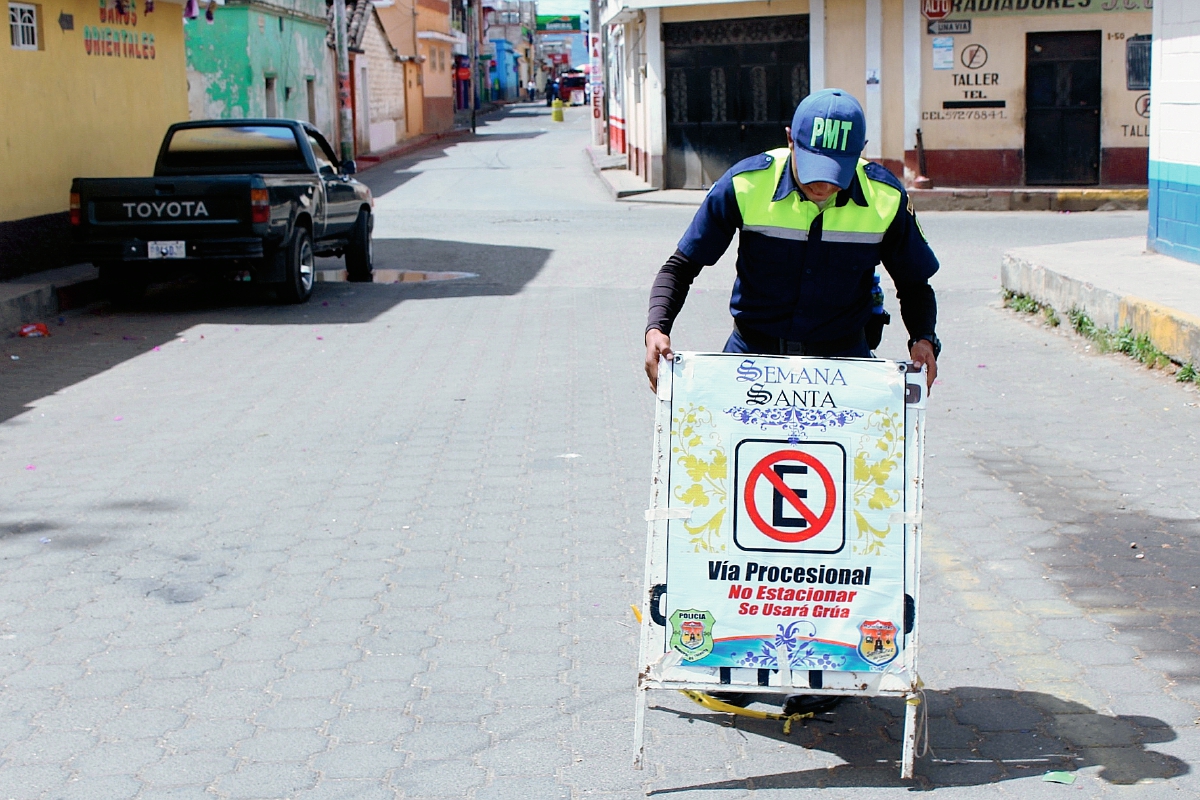 Agente de la Policía Municipal de Tránsito de Santa Cruz del Quiché,  coloca señales en donde está prohibido estacionar vehículos debido al paso de procesiones. (Foto Prensa Libre: Óscar Figueroa)