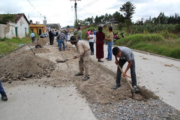 pobladores trabajan para pavimentar carrilera que la comuna destruyó.