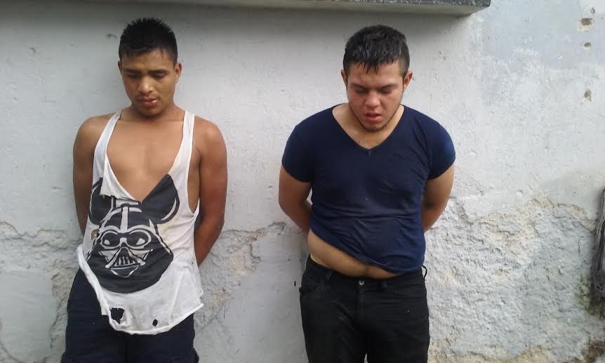 Yerick Estuardo Morán Gonzalez -izquerda- y Kevin Orlando Tuchez Lopez son retenidos por agentes policiales señalados de pertenecer a una banda de asaltantes. (Foto Prensa Libre: Rigoberto Escobar)