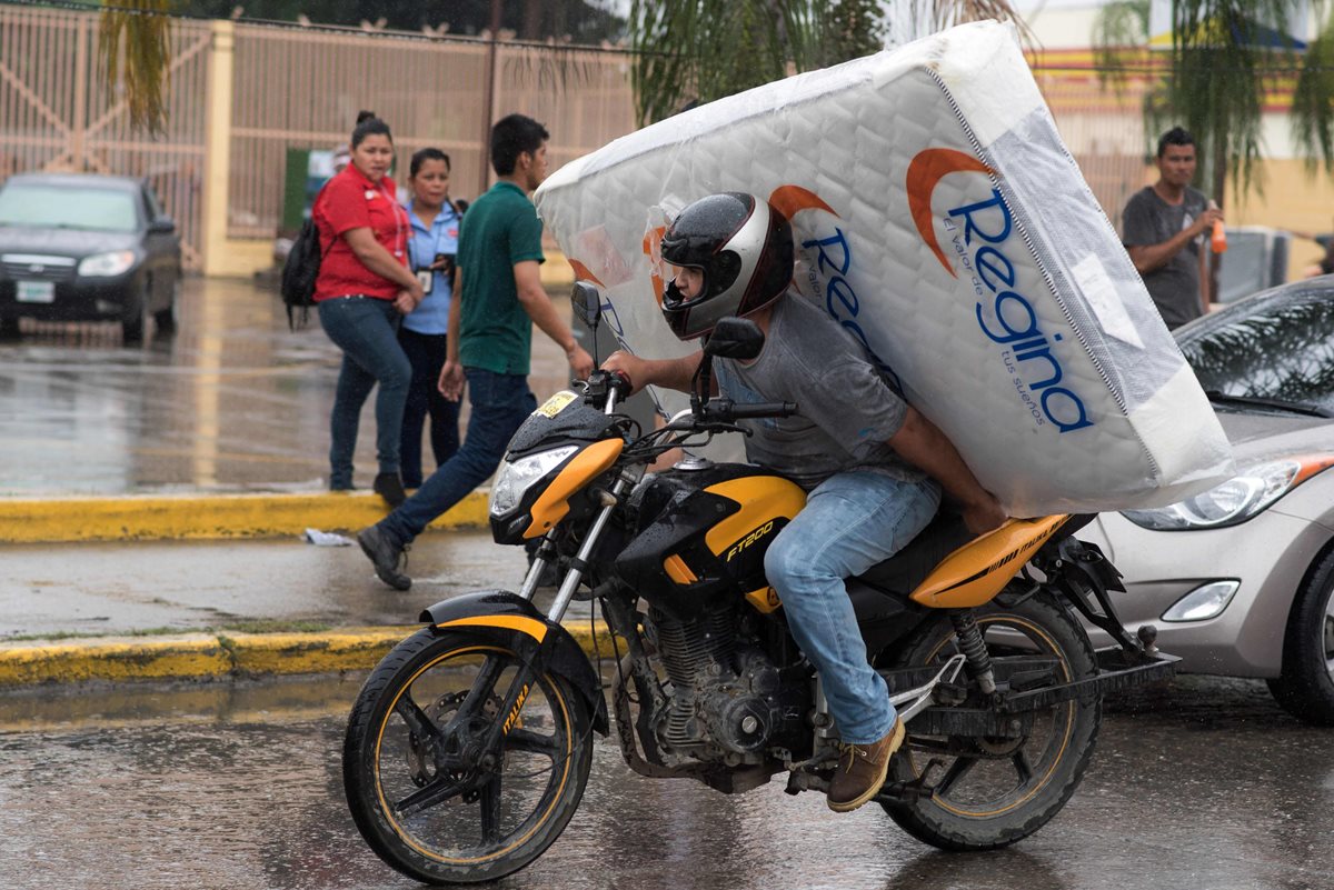 Este manifestante extrae un colchón de una tienda saqueada en San Pedro Sula