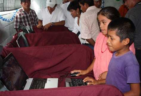 Niños y adultos de la comunidad Ribacó, Baja Verapaz, prueban  el  internet satelital, para el  cual se usa energía solar.