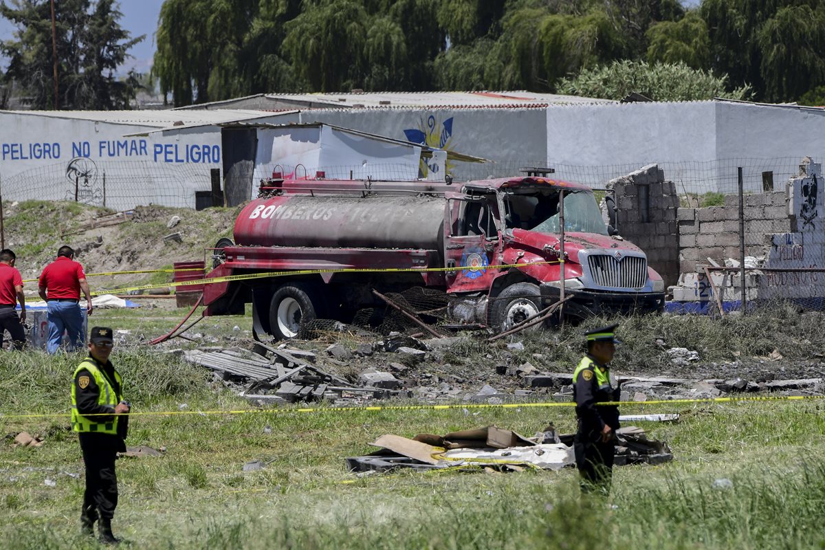Los oficiales de policía hacen guardia en la escena de explosiones en depósitos de fuegos artificiales en Tultepec, México. (Foto Prensa Libre:AFP)