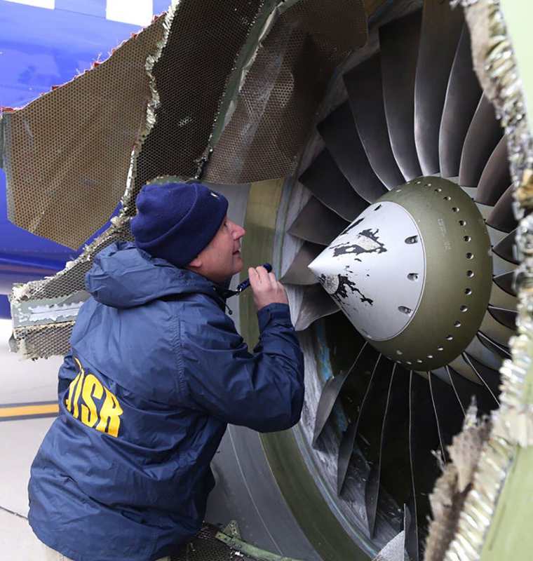 Un investigador de la NTSB en escena examinando los daños al motor del avión de Southwest Airlines.(AFP).