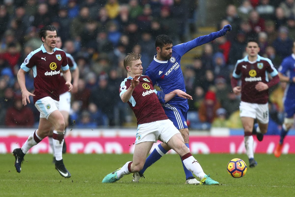 Diego Costa compite por el balón con Ben Mee. (Foto Prensa Libre: AP)