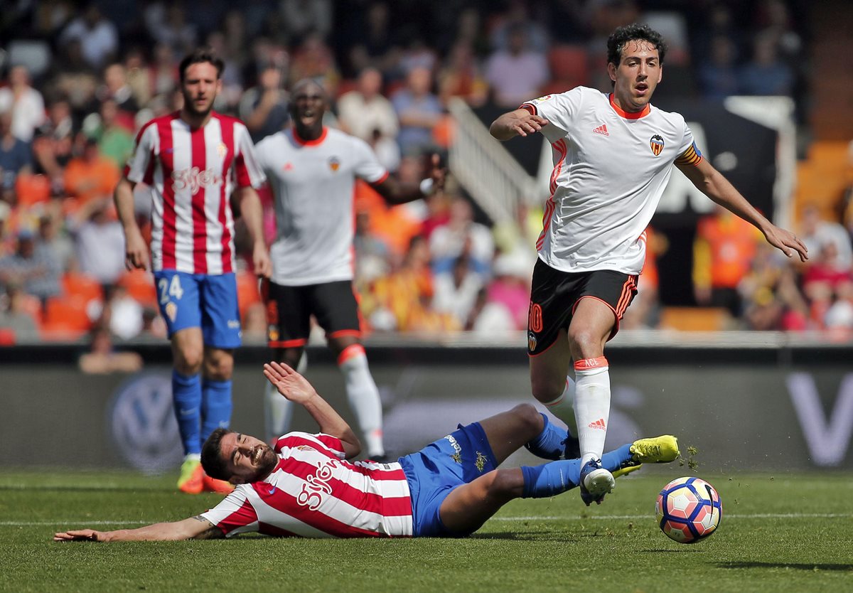 Dani Parejo disputa un balón con el delantero croata del Sporting de Gijón Duje Cop (suelo) durante el partido. (Foto Prensa Libre: EFE)