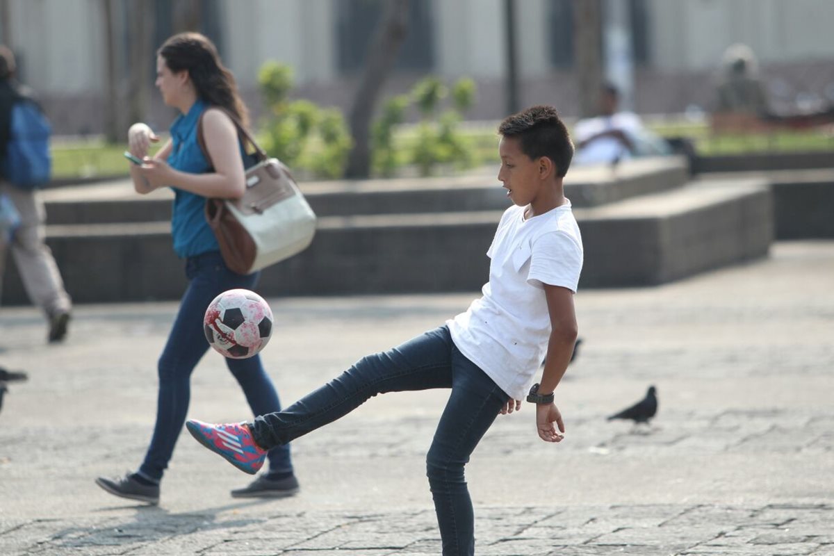 Un niño juega con un balón de futbol que simula estar manchado con sangre. (Foto Prensa Libre: Erick Ávila)