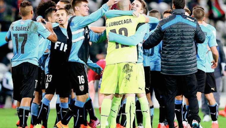 El equipo uruguayo celebra el triunfo por la mínima ante Serbia. (Foto Prensa Libre: EFE)