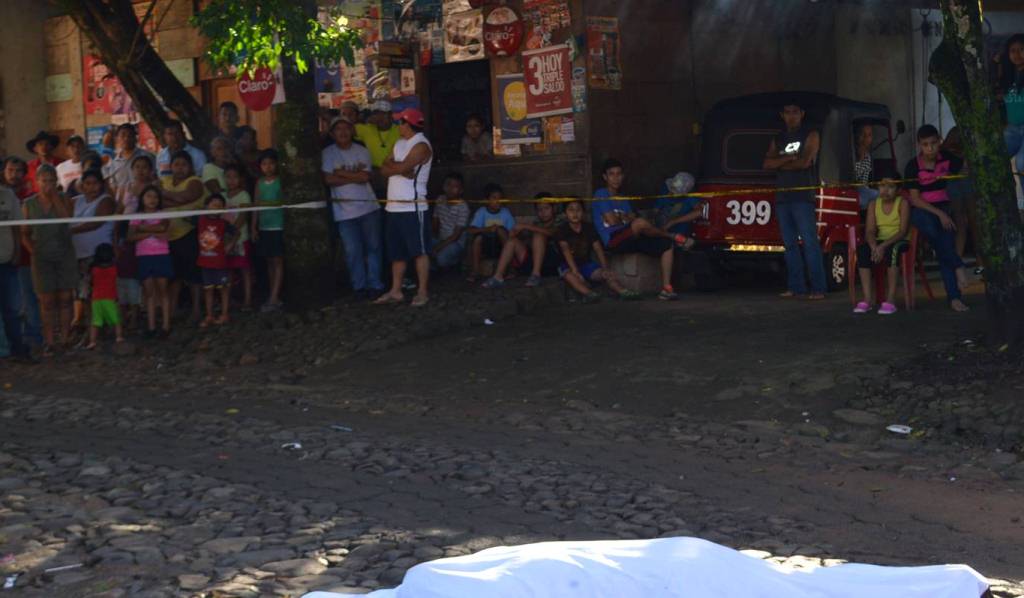 Curiosos observan el cadáver de Roberto Barrios, quien murió baleado en Malacatán, San Marcos. (Foto Prensa Libre: Alexánder Coyoy)