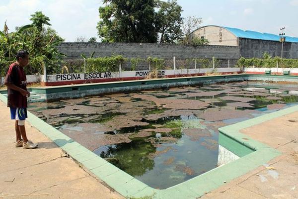 El guardián  del estadio, Félix Velásquez, muestra el estado actual de  la alberca municipal de Retalhuleu. (Foto Prensa Libre: Rolando Miranda)
