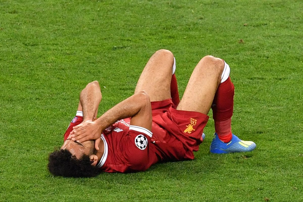 Mohamed Salah terminó tendido en el suelo después de resentirse del hombro por un golpe en una jugada con Sergio Ramos. (Foto Prensa Libre: AFP)