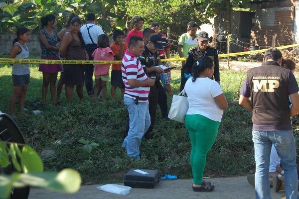 Curiosos observan el cadáver de Juan Alejandro Hernández, quien murió baleado en Tecún Umán. (Foto Prensa Libre: Alexander Coyoy)