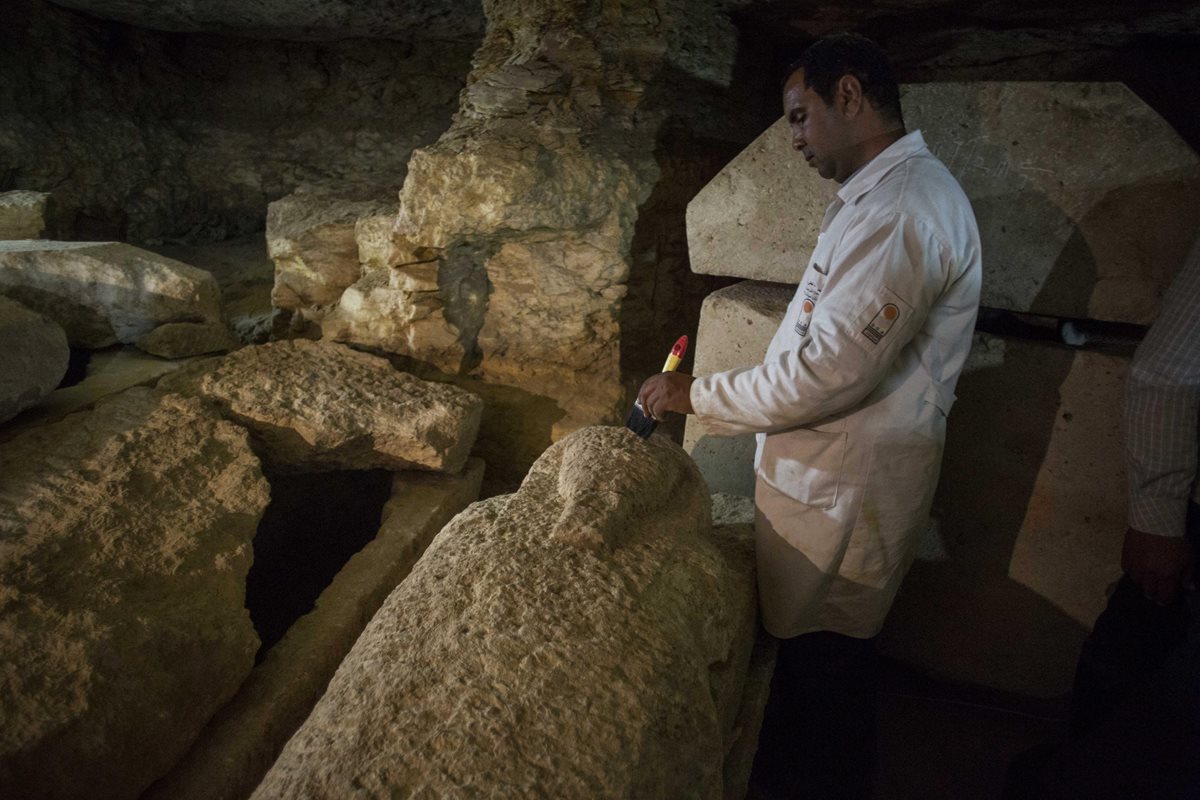 Arqueólogo inspecciona sarcófago hallado en Minya. (Foto Prensa Libre: EFE)